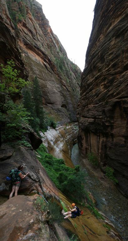 Kate Feller watching as Megan Porter starts down the final rappel of Mystery Canyon into the Zion Narrows.
